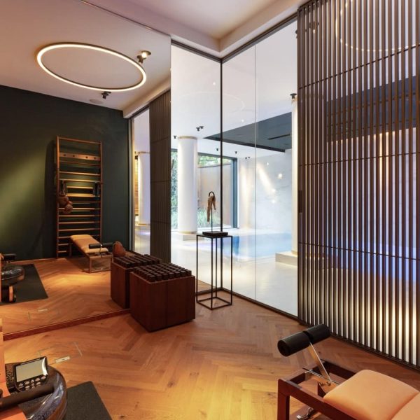 Ein Fitnessraum mit Holzböden und einer Glaswand für einen Hauch von Modernität. | casaceramica