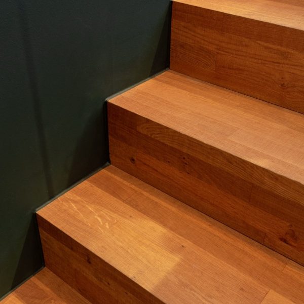 Eine Treppe mit Holzstufen und einer grünen Wand. | casaceramica