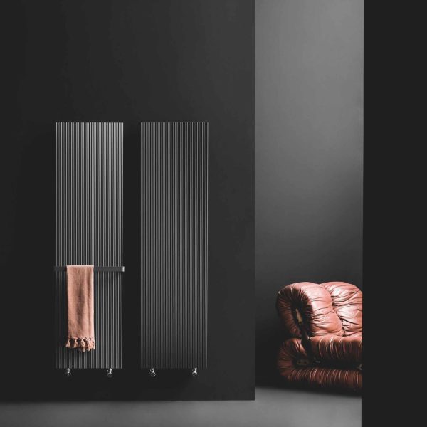 Ein schwarz-graues Zimmer mit einer Couch und einem Heizkörper. | casaceramica