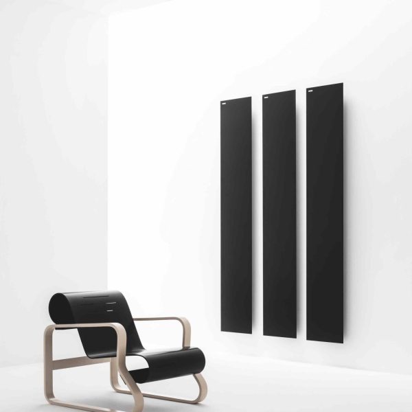 Ein Stuhl vor einem schwarzen Heizkörper in einem weißen Raum auf der Badausstellung. | casaceramica