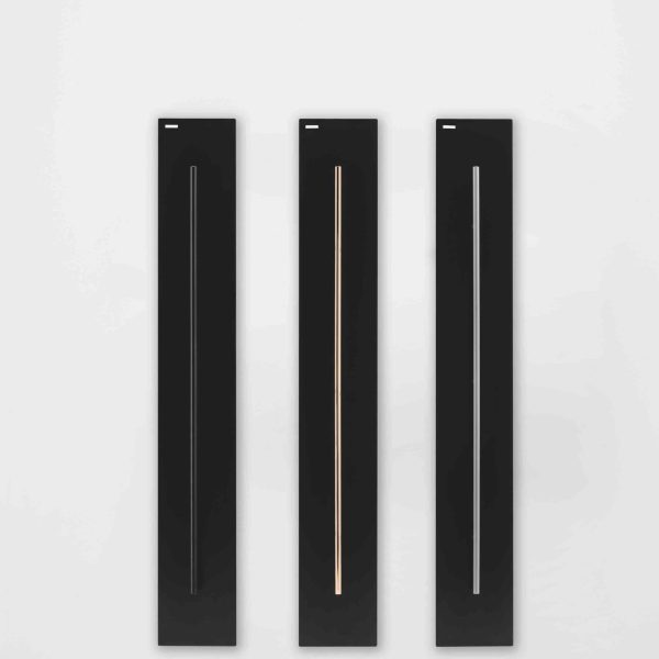 Ein schwarzer Wandheizkörper mit einer weißen Wand dahinter in einer Badausstellung. | casaceramica