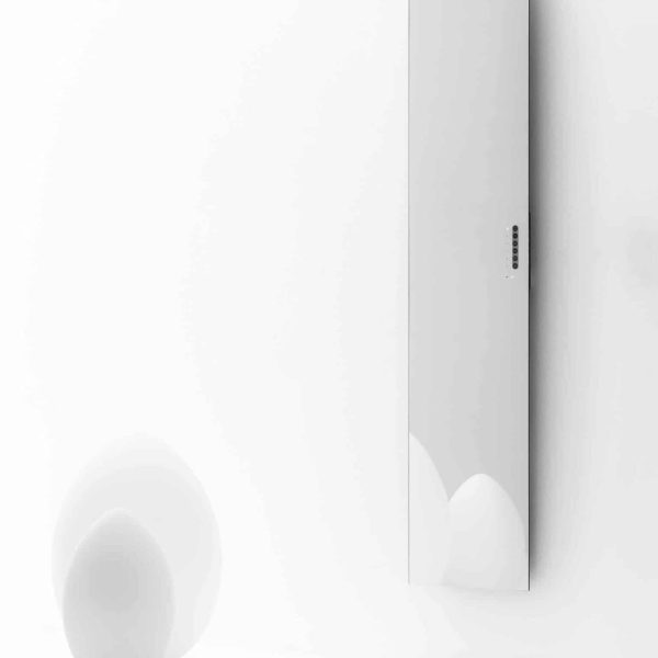 Ein weißer Wandspiegel neben einer weißen Kugel in der Nähe eines Wellnessbereichs. | casaceramica