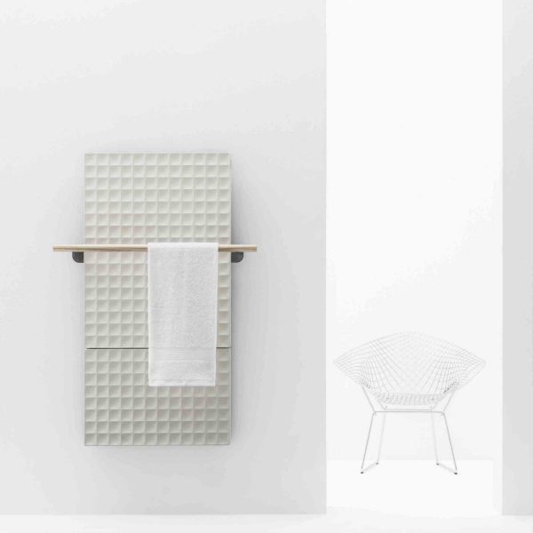 Ein Handtuchhalter in einem weißen Raum mit einem Stuhl auf einer Badausstellung. | casaceramica