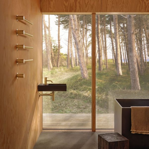 Ein Wellnessbad mit Badewanne und Blick auf ein Waldgebiet. | casaceramica