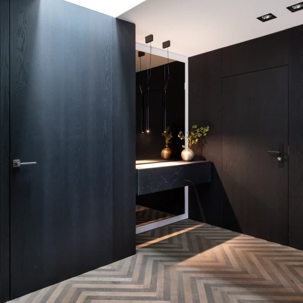 Ein schwarz-weißes Badezimmer mit Chevron-Bodenfliesen, perfekt für einen Wellness-Urlaub im Spa-Stil. | casaceramica