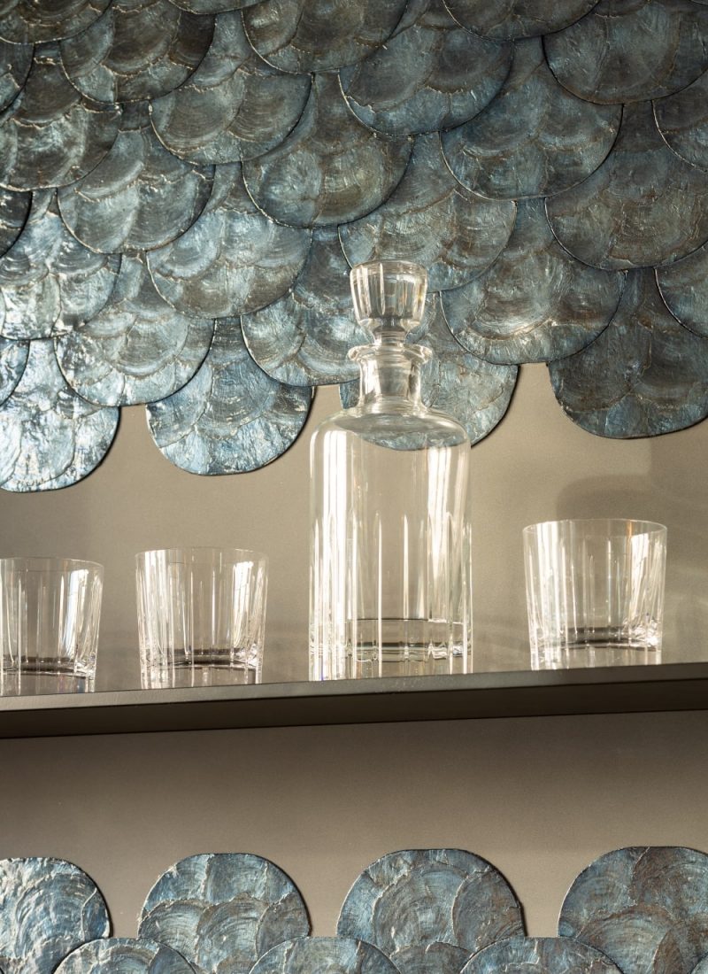 Ein Regal mit Gläsern vor einer blau gefliesten Wand strahlt moderne und stilvolle Atmosphäre aus. | casaceramica