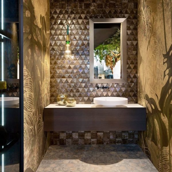Ein Badezimmer mit einer grünen Wand und einem Waschbecken, perfekt für eine Badausstellung. | casaceramica