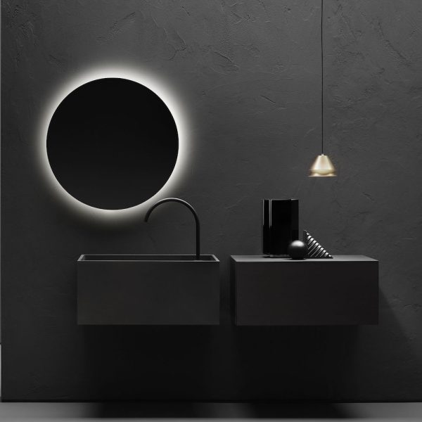 Ein schwarzes Badezimmer mit rundem Spiegel und Waschbecken, perfekt für eine Badausstellung oder einen Hauch Wellness. | casaceramica