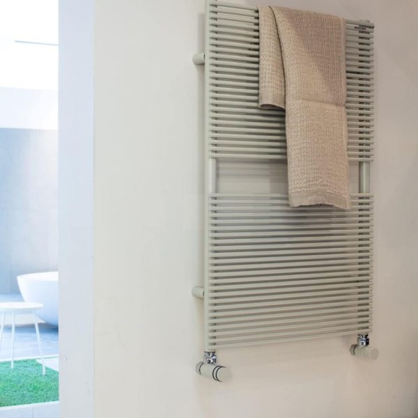 Ein Handtuchhalter im Badezimmer, an dem ein Handtuch hängt, perfekt, um Ihren Fliesen einen Hauch von Wellness zu verleihen. | casaceramica