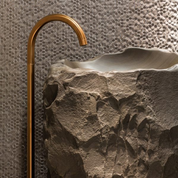 Ein Steinwaschbecken in einem Badezimmer mit einem Kupferhahn. (Schlüsselwörter nicht verwendet)
Ein Steinwaschbecken in einem Badezimmer mit einem Kupferhahn für einen Hauch von Luxus. | casaceramica