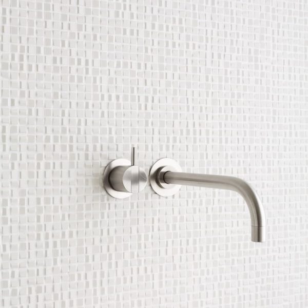 Ein weißes Waschbecken mit einer weiß gefliesten Wand. | casaceramica