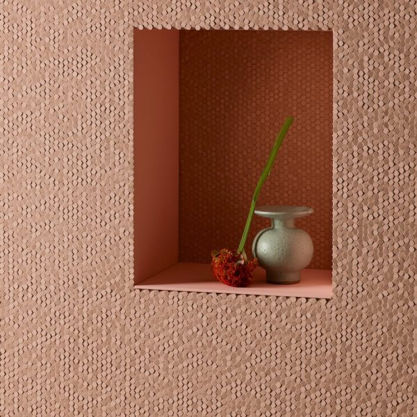 Eine kleine Vase steht auf einer rosa Wand in einer Badausstellung. | casaceramica