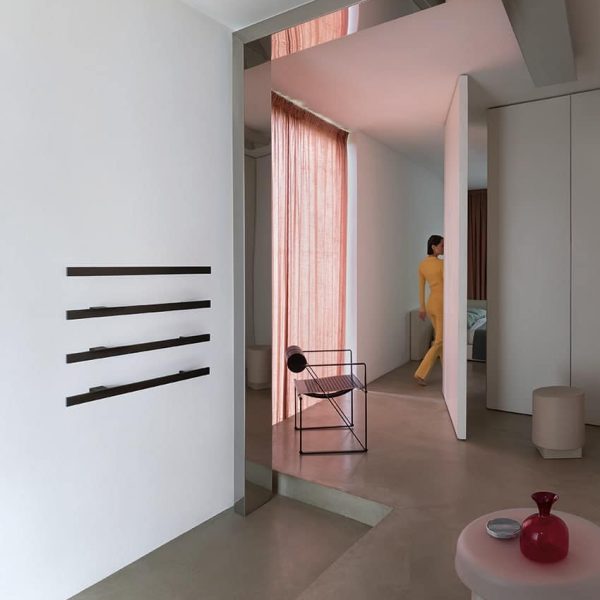 Ein Raum mit weißen Wänden und einem rosa Stuhl. | casaceramica