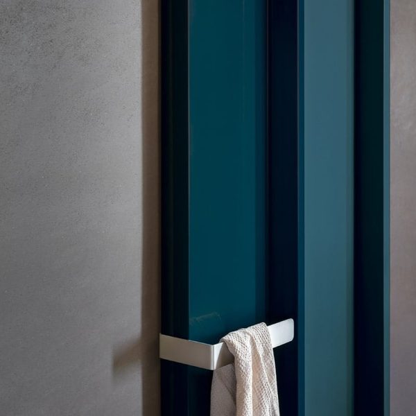 Ein Handtuch hängt an einer blauen Fliesentür in einem Badezimmer. | casaceramica
