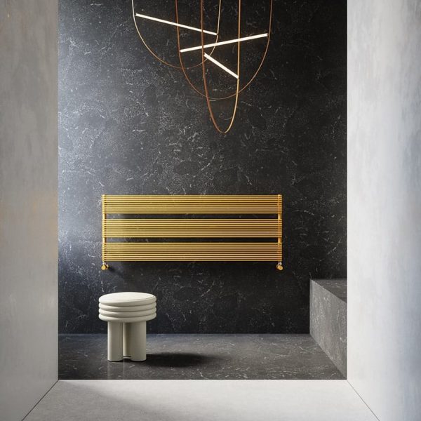 Ein modernes Badezimmer mit goldenem Heizkörper und Fliesen. | casaceramica