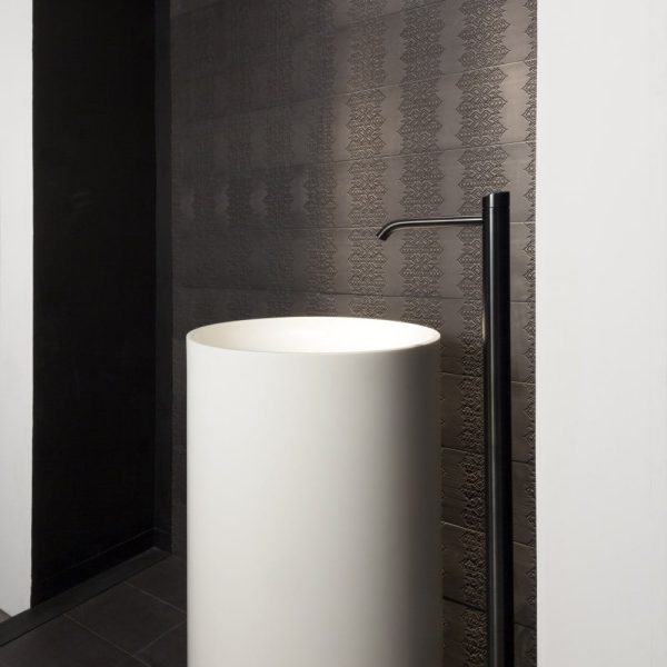 Ein modernes Badezimmer mit weißen Waschbecken und schwarzen Wänden ist sowohl stilvoll als auch elegant. | casaceramica